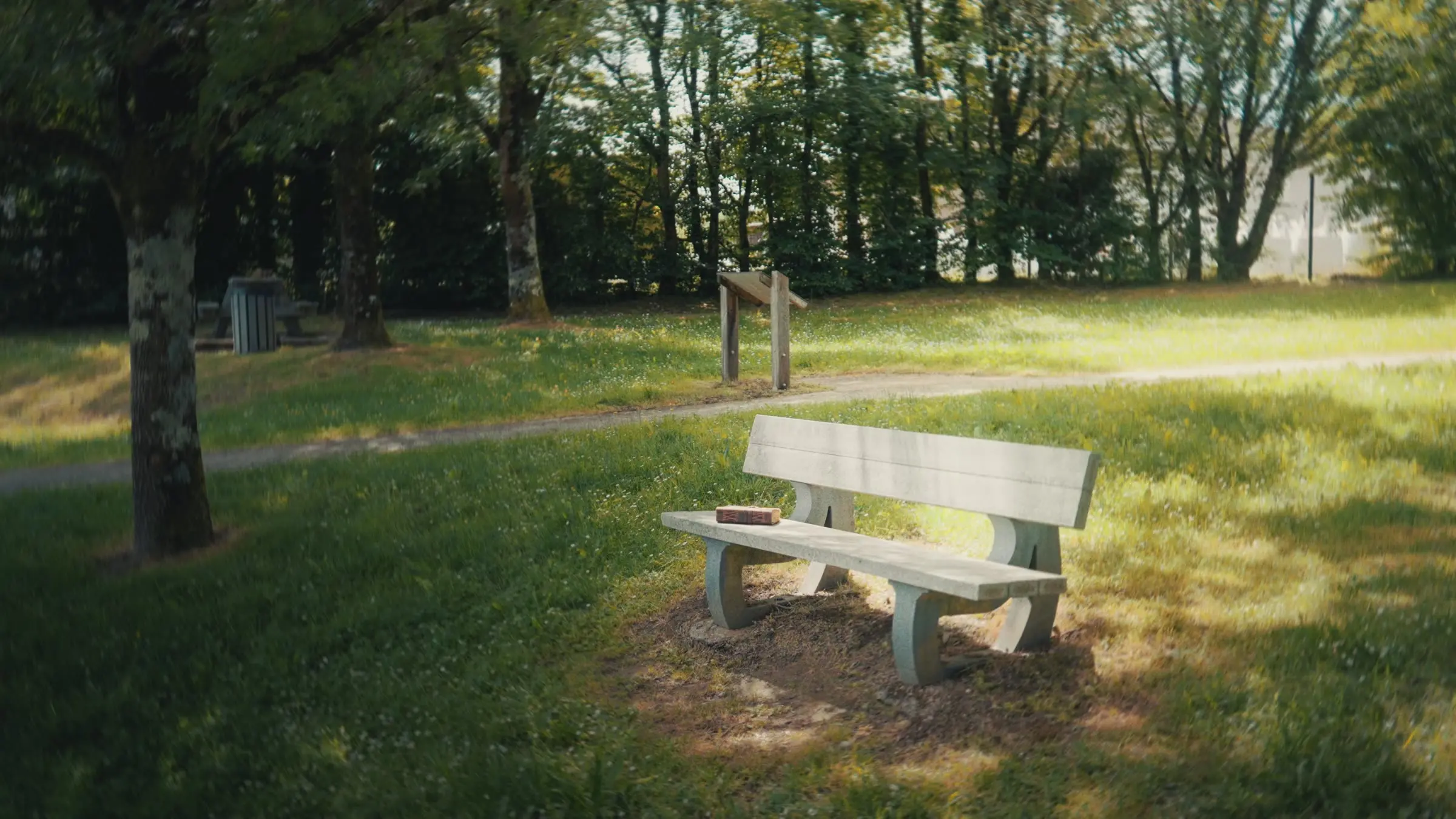 Un banc baigné de soleil dans un parc, un livre posé dessus