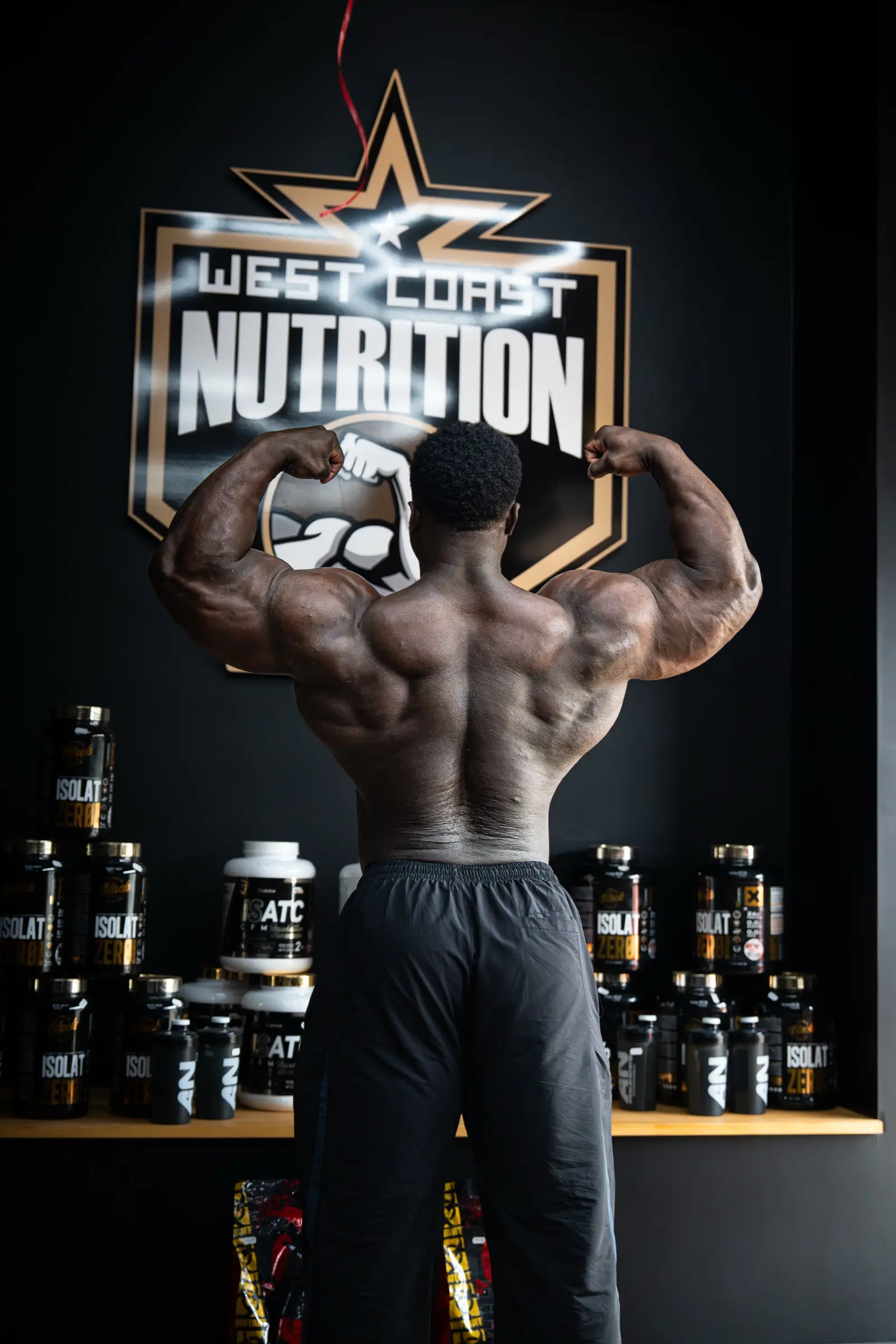 Bodybuilder de dos, double biceps, en salle