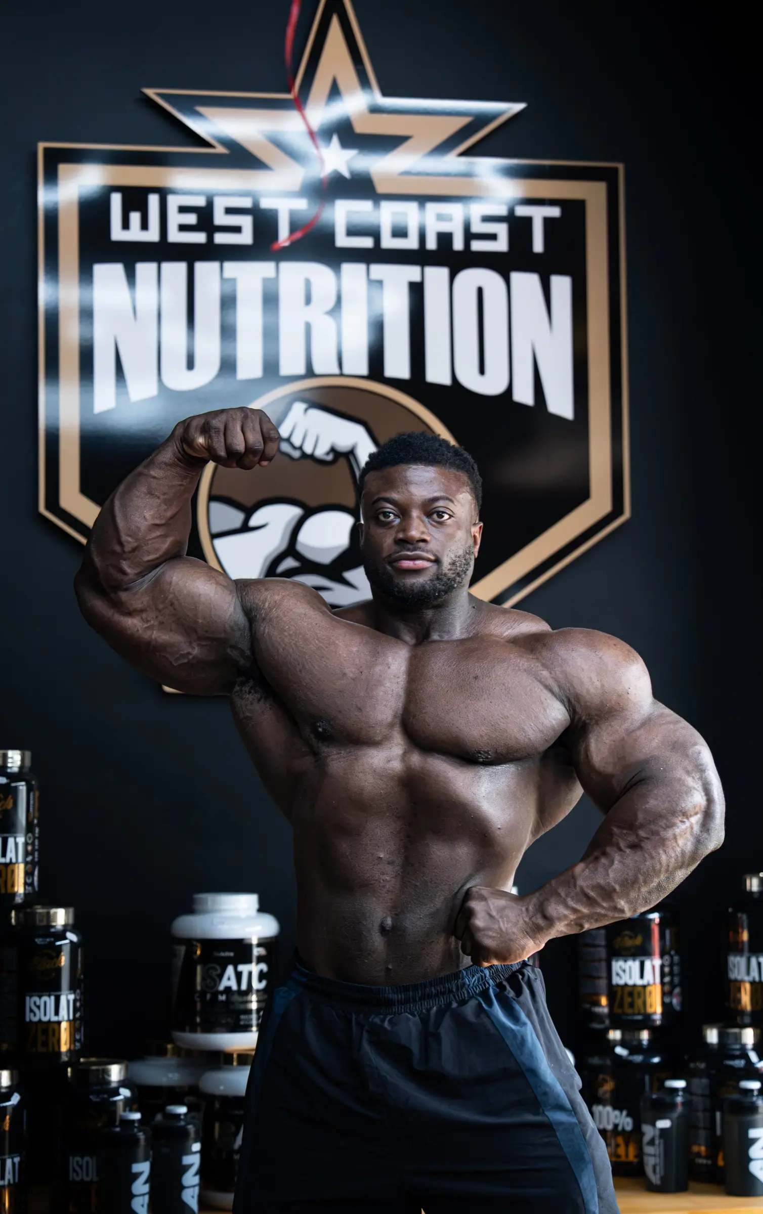 Bodybuilder en pose latérale devant des pots de compléments