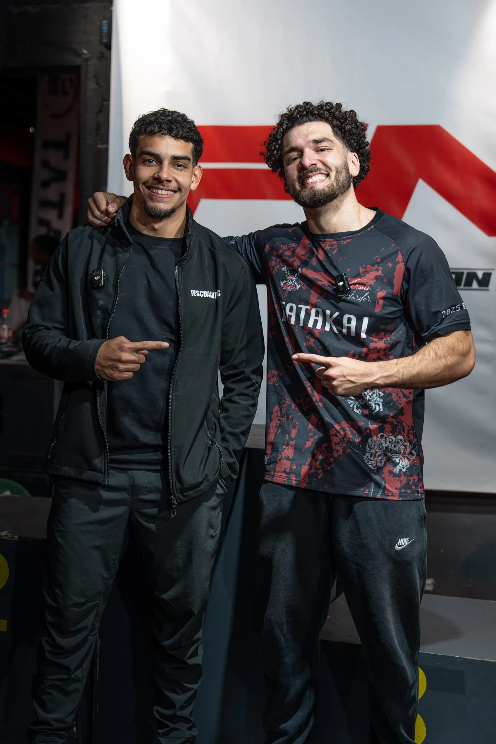 Deux athlètes souriants devant la bannière FNSL aux championnats espoirs 2025