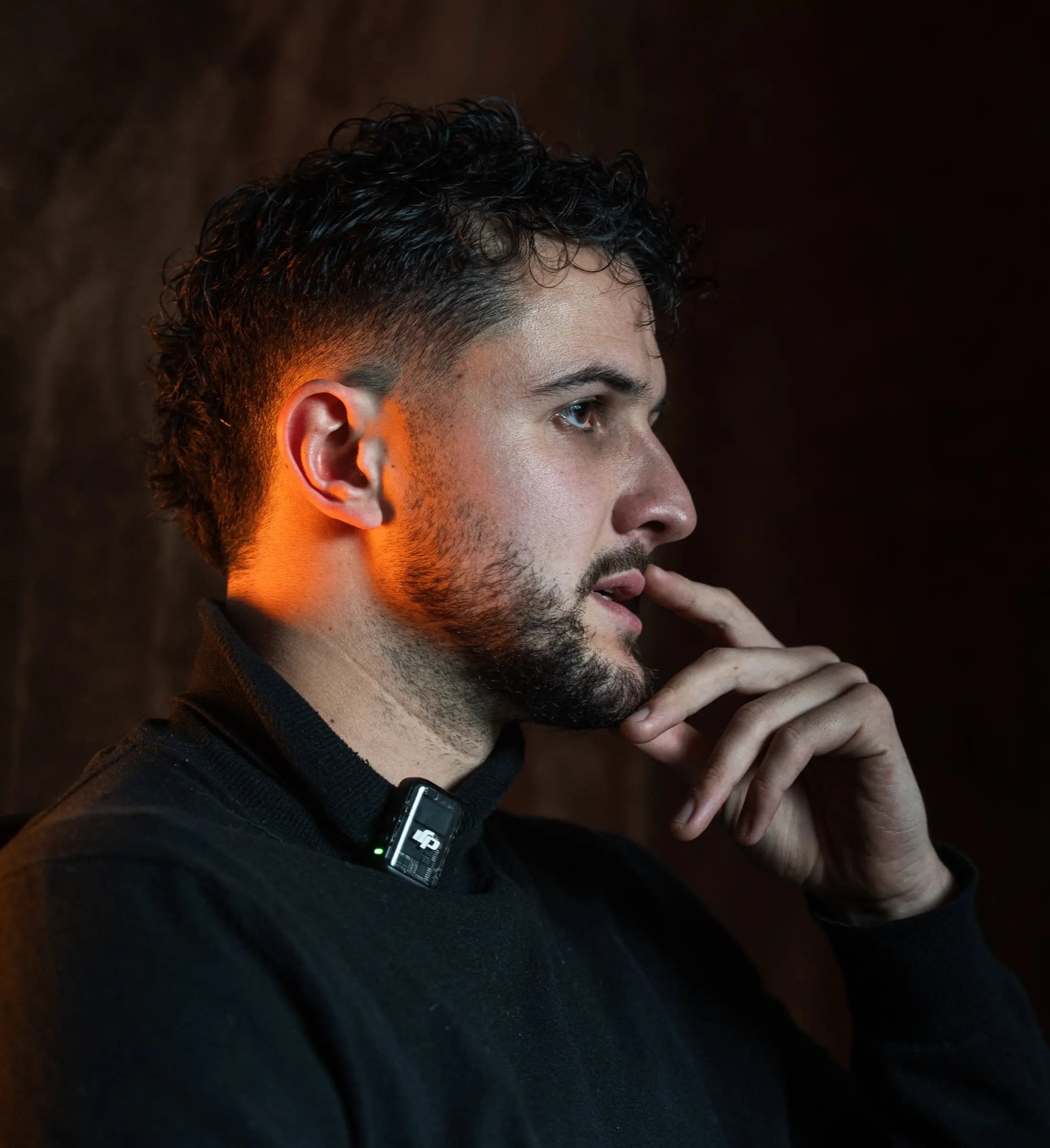 Portrait d'un homme pensif, lumière orangée sur le visage